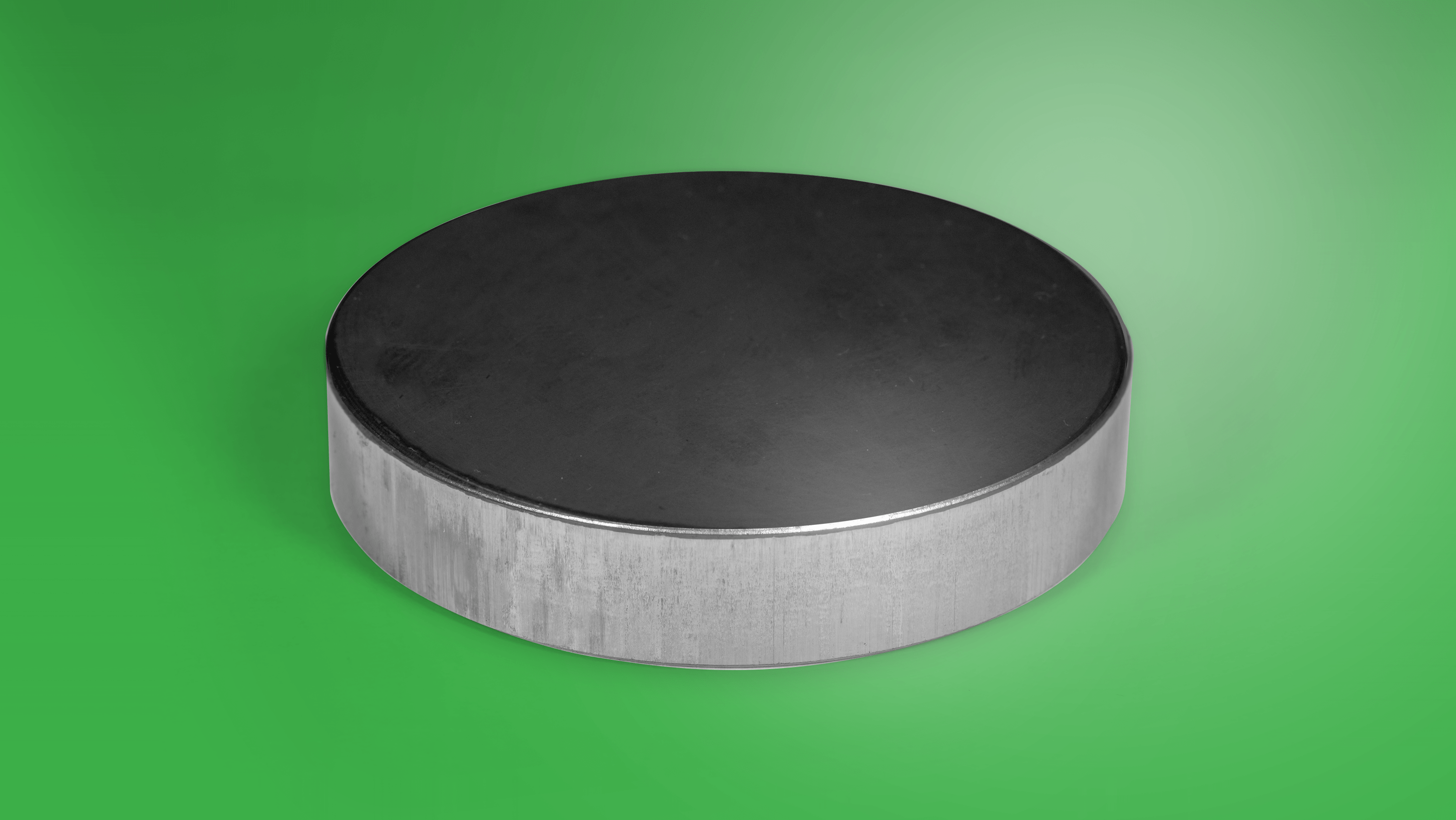 A small metal disc sits on a green background